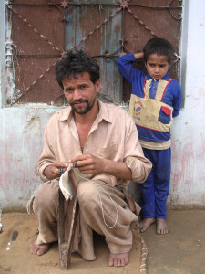 A Sialkot, Pakistan father stitching a rugby ball at home. Copyright © 2007 by Anthony P. Ewing